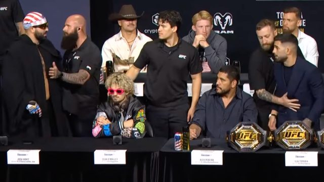 Josh-Hokit-and-Ilia-Topuria-yell-at-each-other-at-a-UFC-press-conference-while-being-separated-by-security.