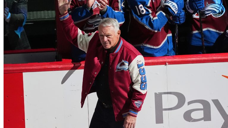 Claude Lemieux waves as he is introduced during a ceremony to honor members from the 1996 Stanley Cup Championship team of the Colorado Avalanche before an NHL hockey game against the Florida Panthers Thursday, Dec. 11, 2025, in Denver. (David Zalubowski/AP)
