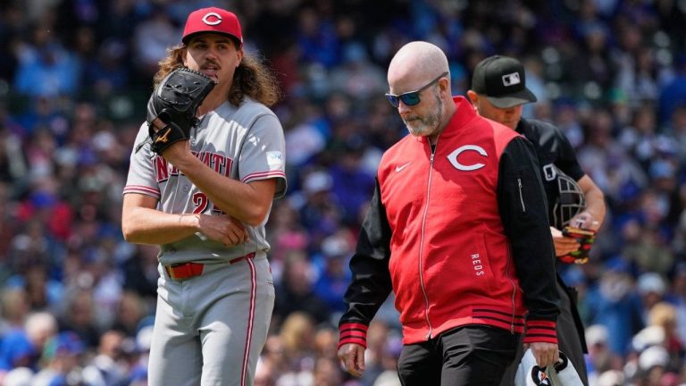 Cincinnati Reds starting pitcher Rhett Lowder, left, leaves as he talks with a team trainer after an injury during the fourth inning of a baseball game against the Chicago Cubs in Chicago, Thursday, May 7, 2026. (Nam Y. Huh/AP)
