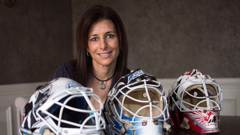 Former goaltender Manon Rheaume poses for a photograph with three of her masks. (Paul Chiasson/THE CANADIAN PRESS)