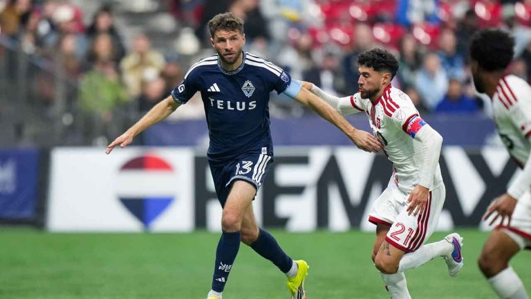 Vancouver Whitecaps' Thomas Muller (13) runs with the ball past Toronto FC's Jonathan Osorio (21) during the second half of an MLS soccer match. (Darryl Dyck/THE CANADIAN PRESS)