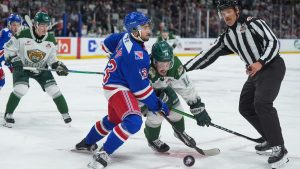 Kitchener Rangers' Haeden Ellis (13) checks Everett Silvertips' Rylan Gould (16) during the first period of the Memorial Cup final hockey game, in Kelowna, B.C., on Sunday, May 31, 2026. ((Darryl Dyck/THE CANADIAN PRESS)