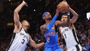 Oklahoma City Thunder guard Shai Gilgeous-Alexander (2) looks to score between San Antonio Spurs forward Keldon Johnson (3) and forward Victor Wembanyama (1) during the second half of an NBA basketball game Tuesday, Jan. 13, 2026, in Oklahoma City. (Nate Billings/AP)