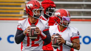 Calgary Stampeders quarterbacks Vernon Adams Jr. (3) and Josh Love (12) look for receivers during opening day of training camp in Calgary, Sunday, May 10, 2026. (Jeff McIntosh/THE CANADIAN PRESS)