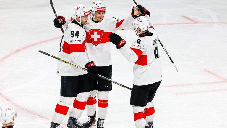 Switzerland's Ken Jager, centre, celebrates with Christian Marti, left, and Damien Riat after scoring the team's third goal during a Group A preliminary round game between United States and Switzerland at the men's ice hockey world championship in Zurich, Switzerland, Friday, May 15, 2026. (Michael Buholzer/Keystone via AP)