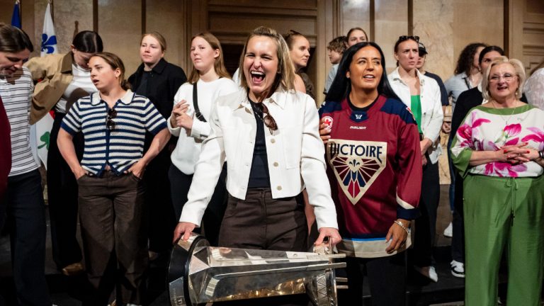 Montreal Victoire's Marie-Philip Poulin reacts while holding the Walter Cup, surrounded by teammates and flanked by Montreal Mayor Soraya Martinez Ferrada, right, at city hall following the PWHL team's Walter Cup victory in Montreal on Tuesday, May 26, 2026. (Christopher Katsarov/CP)