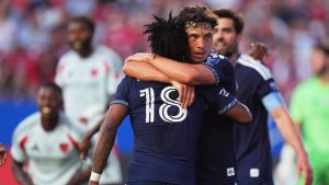 Vancouver Whitecaps FC midfielder Sebastian Berhalter (16) hugs teammate Édier Ocampo (18) after a goal during the first half of an MLS soccer match against FC Dallas in Frisco, Texas, Wednesday, May 13, 2026. (LM Otero/AP Photo)