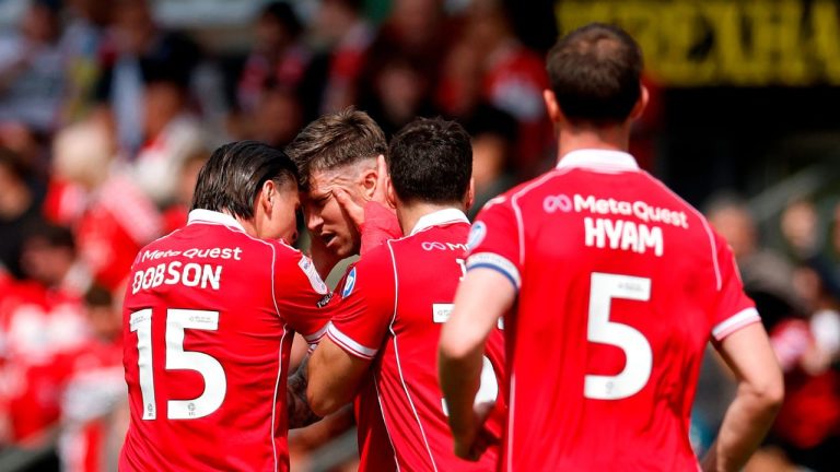 Wrexham's Josh Windass, second left, celebrates scoring his side's first goal of the game with teammates, during the EFL Championship soccer match between Wrexham and Middlesbrough, in Wrexham, Wales, Saturday May 2, 2026. (Cody Froggatt/PA via AP)