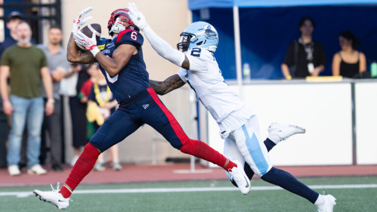 Montreal Alouettes' Tyson Philpot (6) makes a touchdown pass against the Toronto Argonauts' Tarvarus McFadden (2) during first half CFL football action in Montreal on Friday, June 12, 2026. (Christinne Muschi/CP)