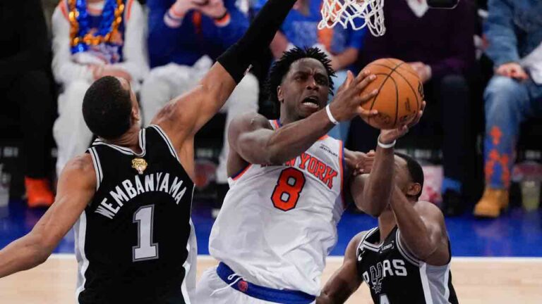 New York Knicks forward Og Anunoby (8) shoots between San Antonio Spurs forward Victor Wembanyama (1) and guard De'aaron Fox (4) during the first half of Game 4 of the NBA Finals basketball series, Wednesday, June 10, 2026, in New York. (Ross D. Franklin/AP)