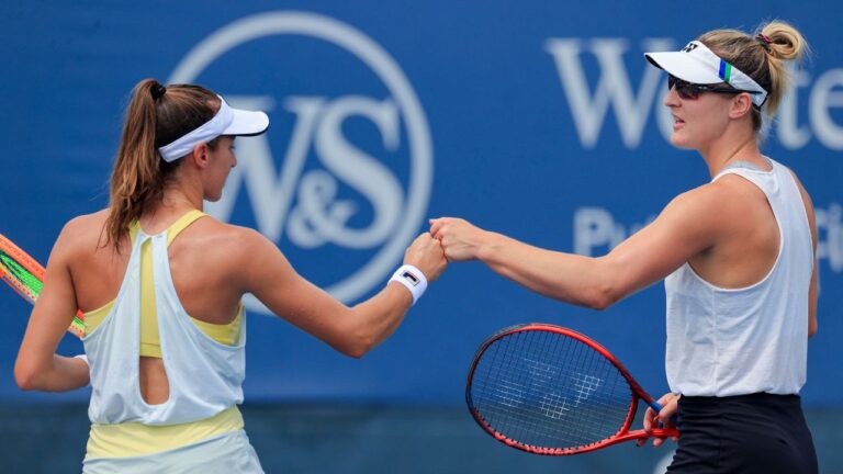 Luisa Stefani, left, of Brazil, bump fists with Gabriela Dabrowski, of Canada during a women's doubles match against Shuko Aoyama and Ena Shibahara, of Japan, at the Western & Southern Open tennis tournament Thursday, Aug. 19, 2021, in Mason, Ohio. (Aaron Doster/AP)