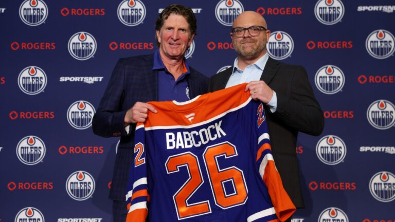 Edmonton Oilers head coach Mike Babcock, left, and general manager Stan Bowman hold up a jersey during a news conference in Edmonton on Tuesday, June 23, 2026. (James Maclennan/CP)