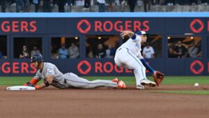 Houston Astros' Jeremy Pena, left, slides safely into second base with a steal ahead of a tag by Toronto Blue Jays infielder Andres Gimenez during first inning MLB baseball action in Toronto, Monday, June 22, 2026. (Jon Blacker/CP)