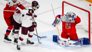 Czechia goaltender Matyas Marik (1) makes a save while teammate Czechia Radim Mrtka defends and Latvia's Rudolfs Berzkalns (7) and Latvia's Daniels Serkins (24) stand in front of the net during third period IIHF World Junior Championship hockey action in Minneapolis on Wednesday, Dec. 31, 2025. (Christopher Katsarov/CP)