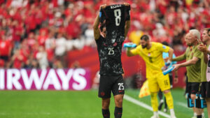 Nathan Saliba holds up the jersey of injured teammate Ismael Kone after scoring his Canada's fourth goal during the World Cup Group B soccer match against Qatar. (Abbie Parr/AP)