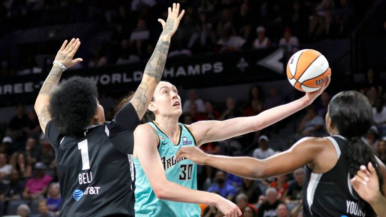 New York Liberty forward Breanna Stewart (30) shoots a layup between Las Vegas Aces forward Kierstan Bell (1) and guard Jackie Young during the first half of an WNBA basketball game Tuesday, June 23, 2026, in Las Vegas. (Steve Marcus/Las Vegas Sun via AP)