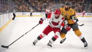 Carolina Hurricanes left wing Jordan Martinook, left, and Vegas Golden Knights defenseman Shea Theodore battle for the puck during the first period in Game 3 of the NHL hockey Stanley Cup Final series Saturday, June 6, 2026, in Las Vegas. (AP Photo/John Locher)
