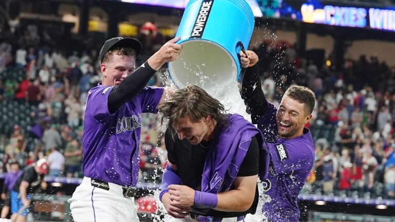 Colorado Rockies' TJ Rumfield, left, and Tyler Freeman, right, douse Jake McCarthy, centre, after McCarthy's three-run walkoff triple to defeat the Boston Red Sox on Monday, June 22, 2026, in Denver. (David Zalubowski/AP)