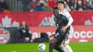Canada's Tani Oluwaseyi, centre, fails to score as he battles with Tunisia's Alaa Ghram as goalkeeper Abdelmouhib Chamakh tries to gather the ball during second half International friendly action in Toronto, on Tuesday March 31, 2026. (Chris Young/CP)