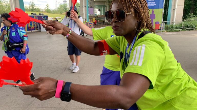 Volunteer Mbalu Lumor hands out "Canadian clappers" to attendees at the FIFA Fan Festival on Wednesday, June 24, 2026, in Toronto. (Mike Householder/AP)