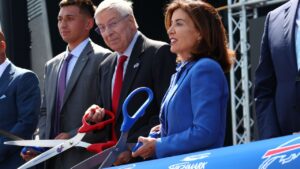 Buffalo Bills owner Terry Pegula, centre, and New York Gov. Kathy Hochul, right, participate in the ribbon cutting ceremony at Highmark Stadium in Orchard Park, N.Y., Tuesday, June 23, 2026. (Jeffrey T. Barnes/AP)