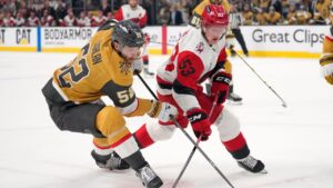 Vegas Golden Knights defenseman Dylan Coghlan, left, and Carolina Hurricanes right wing Jackson Blake battle for the puck during the first period in Game 3 of the NHL hockey Stanley Cup Final series Saturday, June 6, 2026, in Las Vegas. (AP Photo/John Locher)
