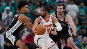 New York Knicks guard Jalen Brunson (11) spins as San Antonio Spurs guard Dylan Harper, left, defends during the first half of Game 1 of the NBA Finals basketball series, Wednesday, June 3, 2026, in San Antonio. (Eric Gay/AP Photo)