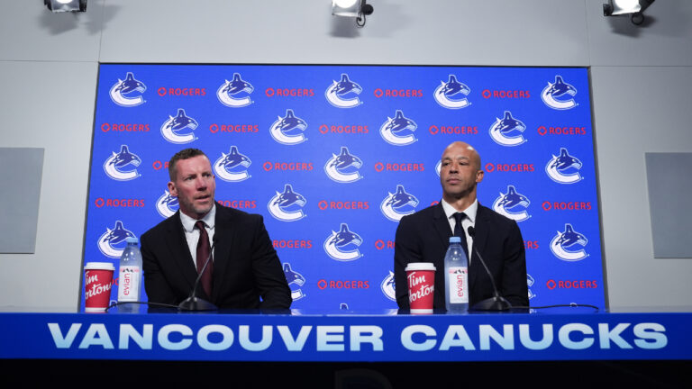 Vancouver Canucks general manager Ryan Johnson, left, and new head coach Manny Malhotra take their seats as they arrive for a news conference, in Vancouver, on Thursday, June 4, 2026. (Darryl Dyck/CP)