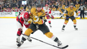Carolina Hurricanes left wing Jordan Martinook, left, and Vegas Golden Knights defenseman Jeremy Lauzon battle for the puck during the third period in Game 4 of the NHL hockey Stanley Cup Final series Tuesday, June 9, 2026, in Las Vegas. (John Locher/AP)