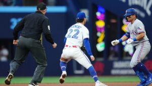 Toronto Blue Jays shortstop Ernie Clement (22) tags out Texas Rangers' Alejandro Osuna (19) in a rundown between first and second base during second inning MLB baseball action in Toronto, on Thursday, June 25, 2026. (Nathan Denette/THE CANADIAN PRESS)