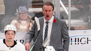 Los Angeles Kings head coach Jim Hiller, center top, gives directions during the third period of an NHL hockey game against the Pittsburgh Penguins in Pittsburgh, Sunday, Nov. 9, 2025. (AP Photo/Gene J. Puskar)