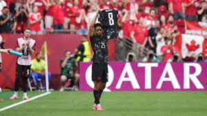 Canada's Nathan Saliba (25) holds up injured teammate Ismael Kone's jersey after scoring against Qatar during the second half of a World Cup Group B soccer match, in Vancouver, on Thursday, June 18, 2026. (Darryl Dyck/CP)