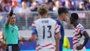 Referee Raphael Claus of Brazil shows a red card to United States' Folarin Balogun, right, during the World Cup round of 32 soccer match between the United States and Bosnia in Santa Clara, Calif., near San Francisco, Wednesday, July 1, 2026. (Julio Cortez/AP)