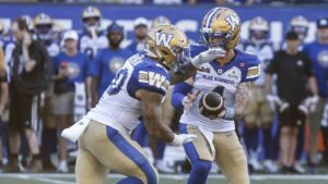 Winnipeg Blue Bombers quarterback Dru Brown (4) hands off to Brady Oliveira (20) during first half CFL football action against the Toronto Argonauts in Winnipeg on Friday, July 10, 2026. (John Woods/CP)