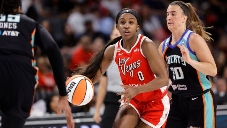 Las Vegas Aces guard Jackie Young (0) drives between New York Liberty centre Jonquel Jones, left, and guard Sabrina Ionescu (20) during the first half of an WNBA basketball game Thursday, July 30, 2026, in Las Vegas. (Steve Marcus/Las Vegas Sun via AP)