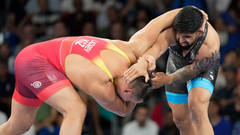 Kyrgyzstan's Aiaal Lazarev, in red, and Canada's Amar Dhesi compete in their men's freestyle 125kg repechage wrestling match, at Champ-de-Mars Arena, during the 2024 Summer Olympics, Saturday, Aug. 10, 2024, in Paris, France. (Eugene Hoshiko/AP)