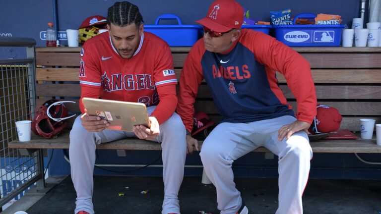 Los Angeles Angels' Jose Siri, left, looks at an iPad in the dugout with Angels' assistant hitting coach Jobel Jiménez during a baseball game against the Los Angeles Dodgers, Sunday, June 7, 2026, in Los Angeles. (AP Photo/Jayne Kamin-Oncea)