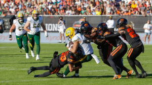 Edmonton Elks' Austin Mack (3) is swarmed by the B.C. Lions defence during second-half CFL football action in Kelowna, B.C., on Saturday, July 4, 2026. (Steve Dunsmoor/CP)