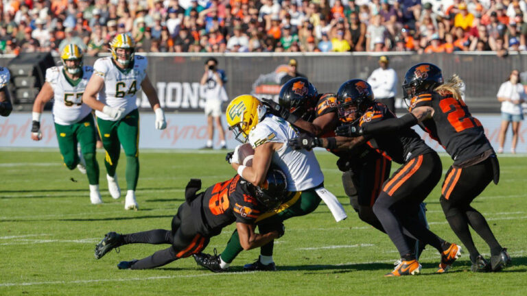 Edmonton Elks' Austin Mack (3) is swarmed by the B.C. Lions defence during second-half CFL football action in Kelowna, B.C., on Saturday, July 4, 2026. (Steve Dunsmoor/CP)