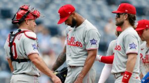 Philadelphia Phillies pitcher Cristopher Sanchez, center, is consoled by catcher J.T. Realmuto, left, and first baseman Bryce Harper, front right, as he is taken out during the fourth inning of a baseball game against the Kansas City Royals in Kansas City, Mo., Monday, July 6, 2026. (Colin E. Braley/AP)