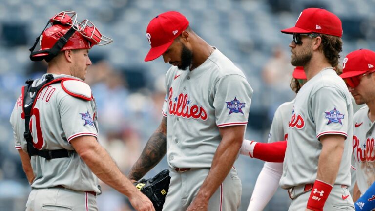 Philadelphia Phillies pitcher Cristopher Sanchez, center, is consoled by catcher J.T. Realmuto, left, and first baseman Bryce Harper, front right, as he is taken out during the fourth inning of a baseball game against the Kansas City Royals in Kansas City, Mo., Monday, July 6, 2026. (Colin E. Braley/AP)