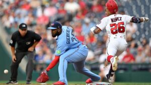 Washington Nationals' Nasim Nunez (26) beats out a throw to Toronto Blue Jays first baseman Vladimir Guerrero Jr., center, during the second inning of a baseball game, Monday, July 27, 2026, in Washington. (John McDonnell/AP)