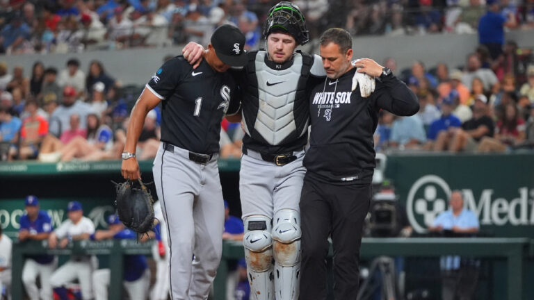 Chicago White Sox catcher Kyle Teel, centre, is helped off the field by manager Will Venable (1) and trainer Brett Walker, right, during the second inning of a baseball game against the Texas Rangers, Monday, July 20, 2026, in Arlington, Texas. (LM Otero/AP)