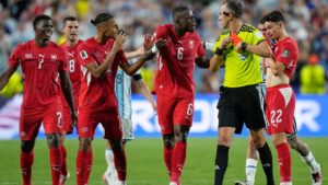 Swiss players remonstrate with referee Joao Pinheiro, of Portugal after teammate Breel Embolo (7) was given a red card during the World Cup quarterfinal soccer match between Argentina and Switzerland in Kansas City, Mo., Saturday, July 11, 2026. (AP Photo/Ashley Landis)