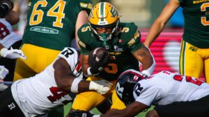 Edmonton Elks' Justin Rankin (5) is tackled by Ottawa Redblacks' Luiji Vilain (left) and Adrian Frye (22) during first half CFL football action in Edmonton on Thursday, July 9, 2026. THE CANADIAN PRESS/Codie McLachlan
