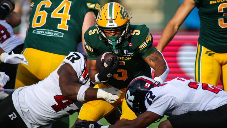 Edmonton Elks' Justin Rankin (5) is tackled by Ottawa Redblacks' Luiji Vilain (left) and Adrian Frye (22) during first half CFL football action in Edmonton on Thursday, July 9, 2026. THE CANADIAN PRESS/Codie McLachlan