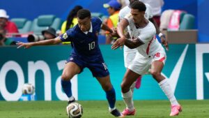 England's Jarell Quansah (26) challenges France's Kylian Mbappe (10) during the World Cup third-place playoff soccer match between France and England in Miami Gardens, Fla., Saturday, July 18, 2026. (AP Photo/Lynne Sladky)