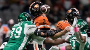 Saskatchewan Roughriders' Charleston Hughes, left, strips the ball from B.C. Lions quarterback Danny O'Brien during a CFL game in Vancouver. (Darryl Dyck/CP)