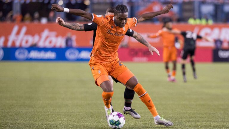 Forge FC's Kwasi Poku (front) fights for the ball with Cavalry FC's Fraser Aird during the Canadian Premier League finals in Hamilton on Saturday, Oct. 28, 2023. (Nick Iwanyshyn/CP)