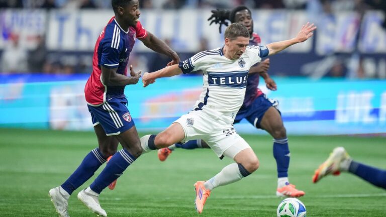 Vancouver Whitecaps' Ryan Gauld, front right, is upended by FC Dallas' Osaze Urhoghide during the second half in Game 1 of a first round MLS Cup playoff soccer match, in Vancouver, B.C., Sunday, Oct. 26, 2025. (Darryl Dyck/CP)